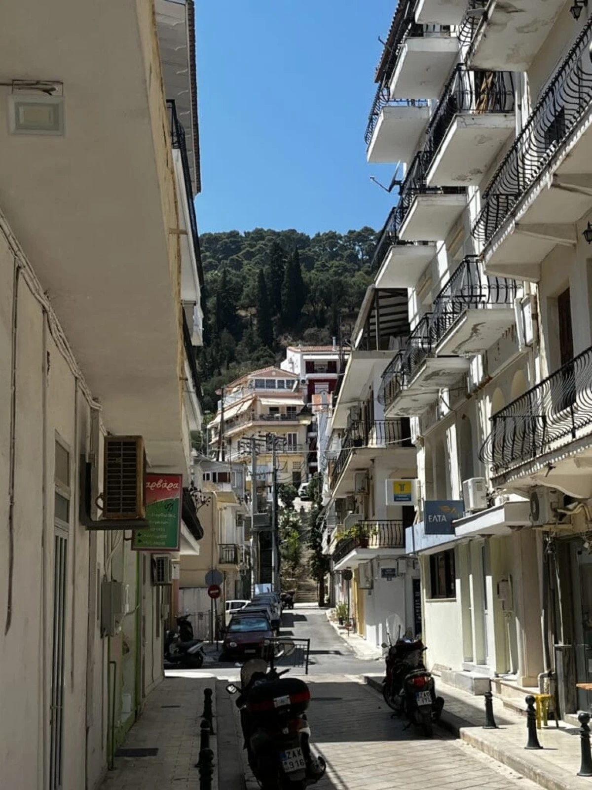 Wąska uliczka w centrum Zakynthos. Na drugim planie widzimy wzgórze Bohali